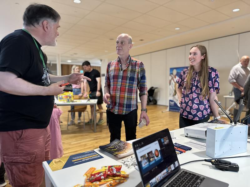 Alan and Nikki speaking about telecoms to a stand visitor